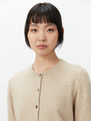 Women's Warm Grey Cashmere Crew Neck Cardigan worn by model, detail view on white background
