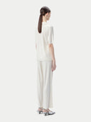 Women's Silk Cashmere Polo Shirt Whisper White worn by model, back view on white background
